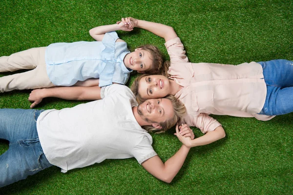 Família deitada na grama — Fotografia de Stock