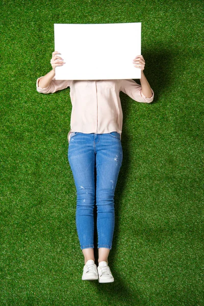 Mujer con pancarta en blanco en la hierba - foto de stock