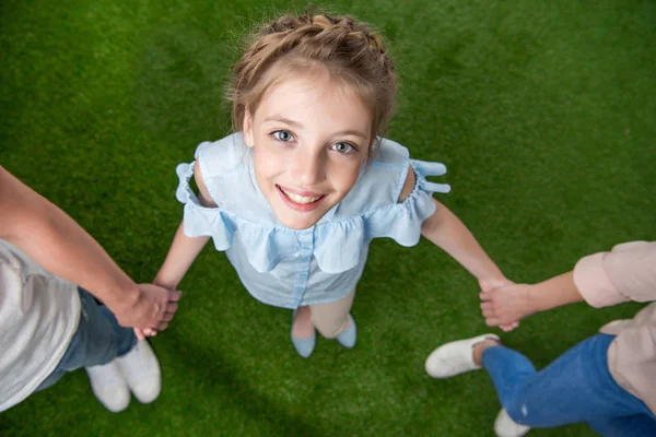 Little girl with parents standing on grass — Stock Photo