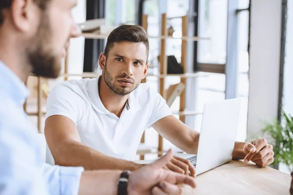 Hombre de negocios en reunión con compañeros de trabajo - foto de stock