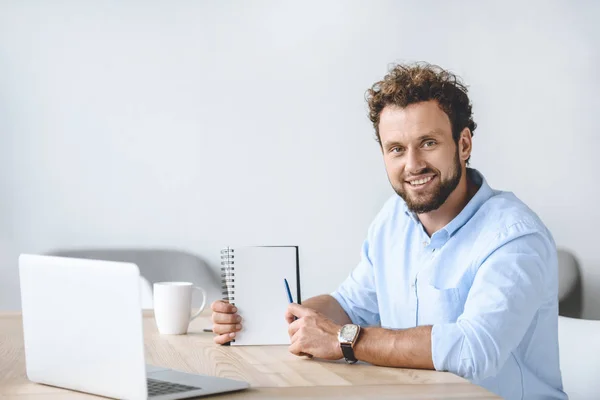 Businessman pointing at notebook — Stock Photo