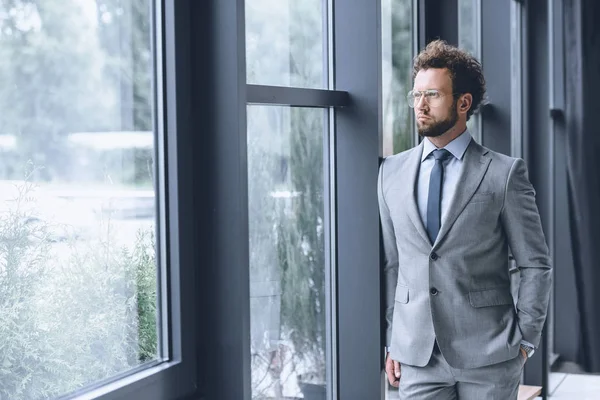 Hombre de negocios pensativo en traje - foto de stock