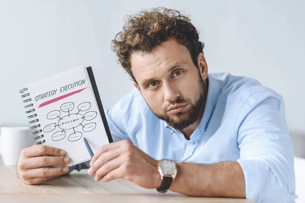 Hombre de negocios apuntando al cuaderno - foto de stock