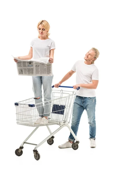 Woman with newspaper in shopping cart — Stock Photo