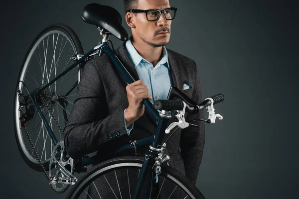 Homme d'affaires dans l'usure formelle tenant vélo — Photo