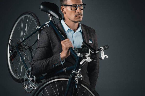 businessman in formal wear holding bicycle