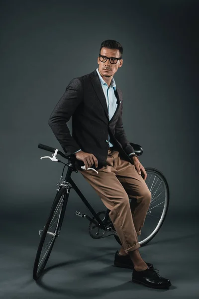 Young stylish businessman sitting on bicycle — Stock Photo, Image