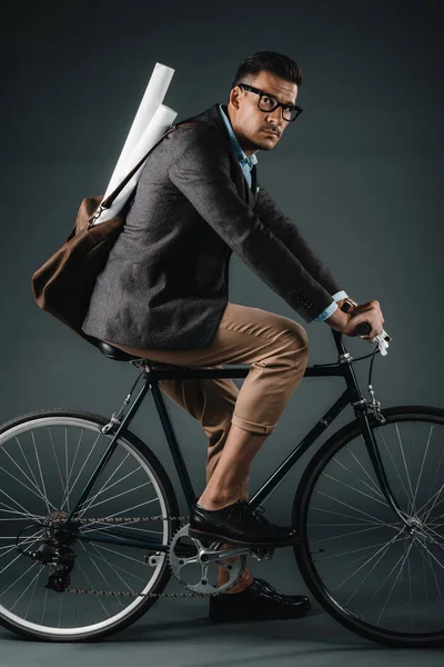 Young businessman with bag riding on bicycle — Stock Photo, Image