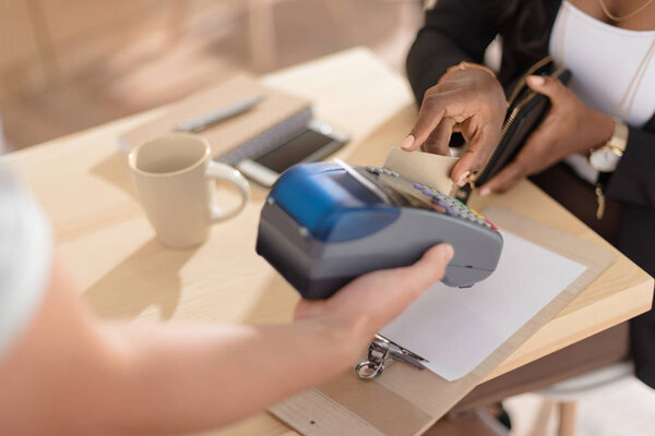 woman paying with credit in cafe 