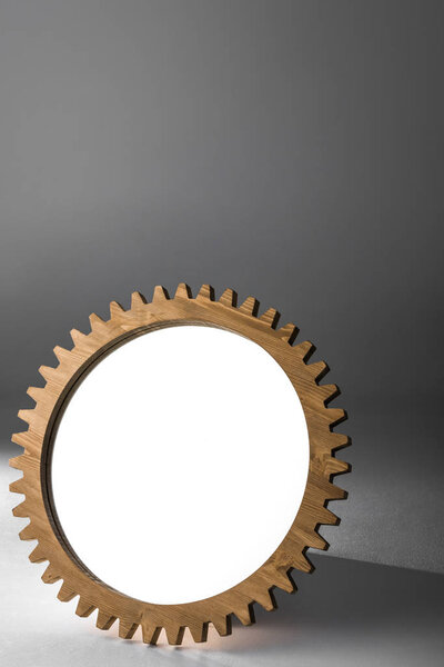 mirror framed by wooden cogwheel