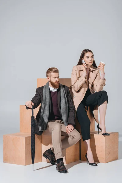 Pareja elegante con café para llevar y teléfono inteligente — Foto de Stock