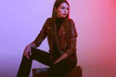 Kız bavulun üzerinde oturuyor.