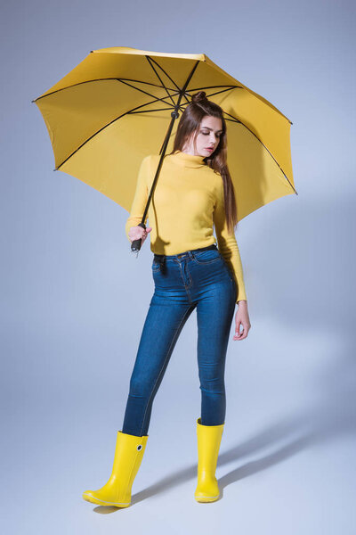 girl in rubber boots with umbrella