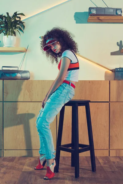 Femme à la mode assis sur tabouret de bar — Photo