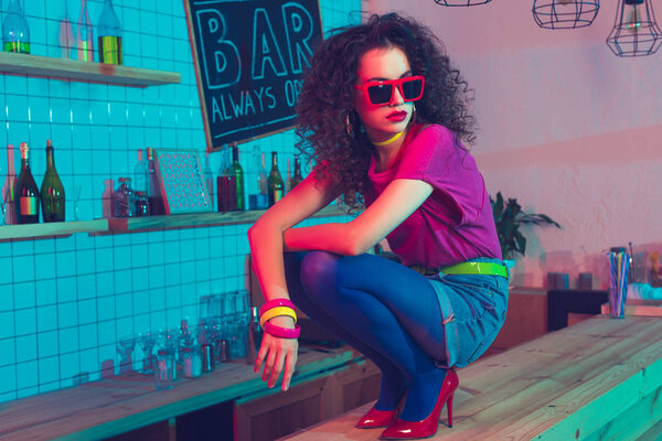 стильная женщина, сидящая на прилавке
