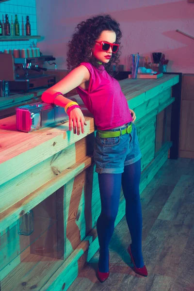 Fashionable woman leaning on counter — Stock Photo, Image