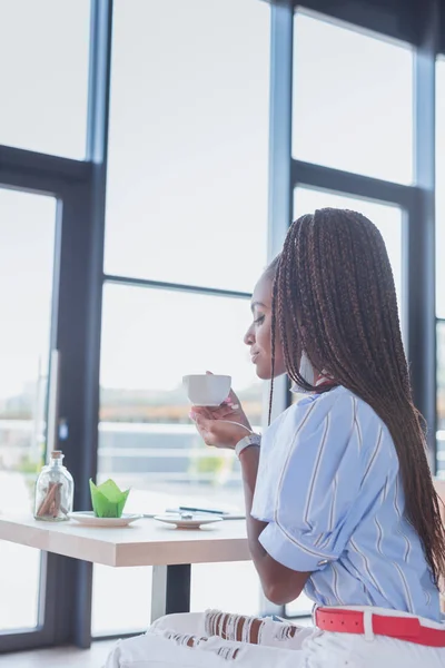 Donna afro-americana che beve caffè nel caffè — Foto Stock