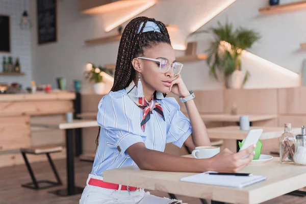 Mujer afroamericana usando smartphone en cafetería — Foto de Stock