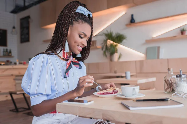 Africano americano mulher comer torta no café — Fotografia de Stock