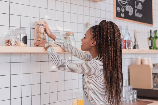 barista taking glass jar wth cookies