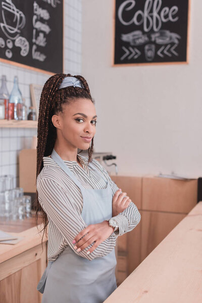 бариста, стоящая со скрещенными руками
