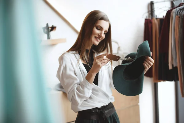 Smiling woman choosing hat — Stock Photo, Image