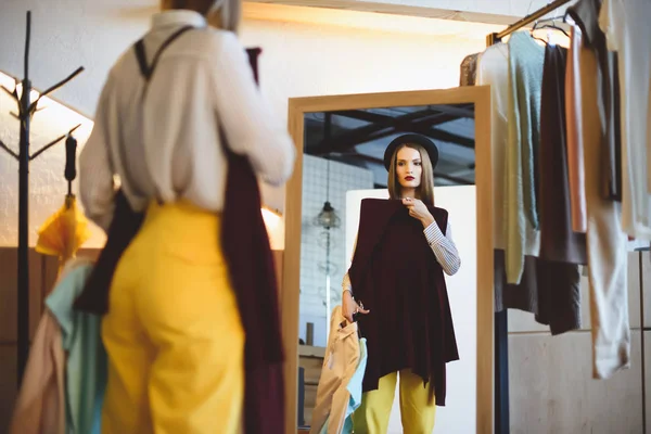 Girl in hat choosing clothes — Stock Photo, Image