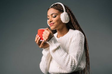 girl in fur earmuffs holding cup clipart