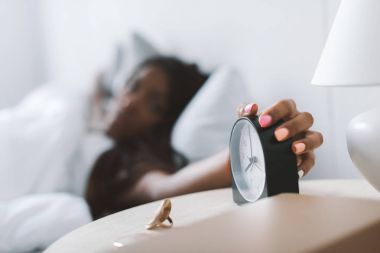 woman turning alarm clock off clipart