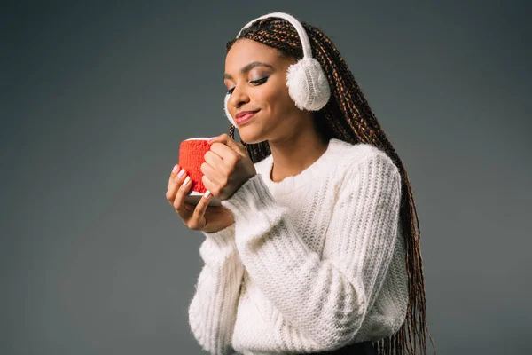 Fille en fourrure cache-oreilles tenant tasse — Photo