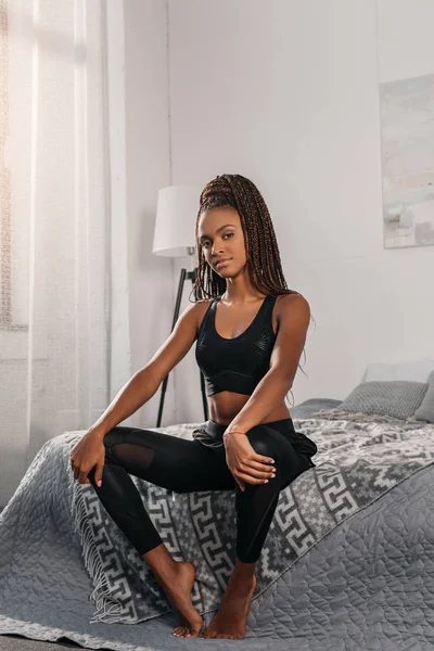Mujer en ropa deportiva sentada en la cama —  Fotos de Stock