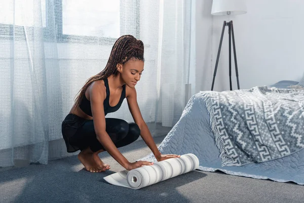 Woman rolling out yoga mat — Stock Photo, Image