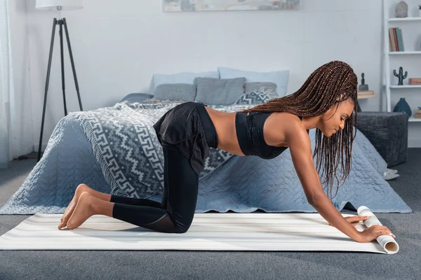 Mujer desplegando estera de yoga — Foto de Stock