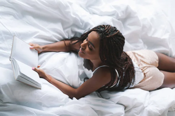 Kobieta czyta książkę w łóżku — Zdjęcie stockowe