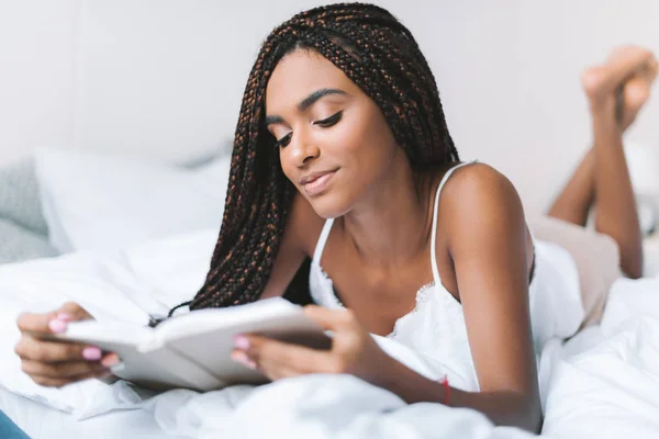 Žena čtení knihy v posteli — Stock fotografie