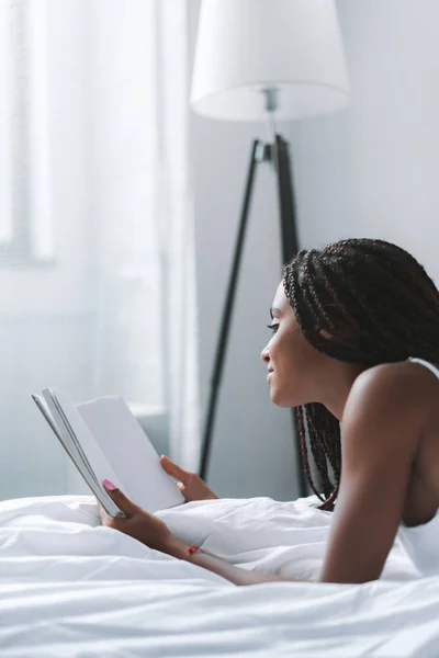 Mujer leyendo libro en la cama — Foto de Stock