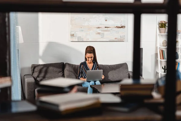 Woman using laptop on couch — Stock Photo, Image