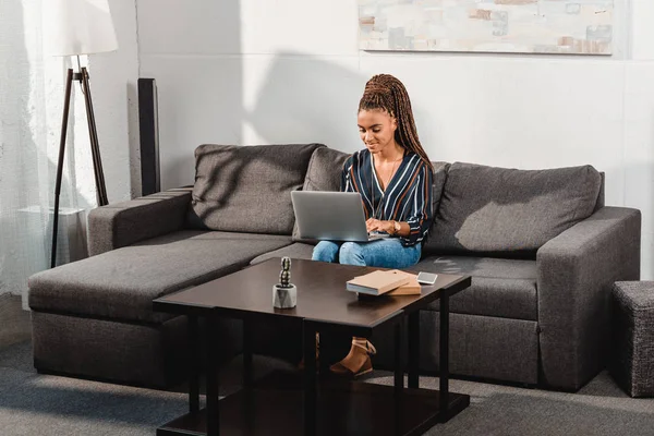 Frau benutzt Laptop auf Couch — Stockfoto