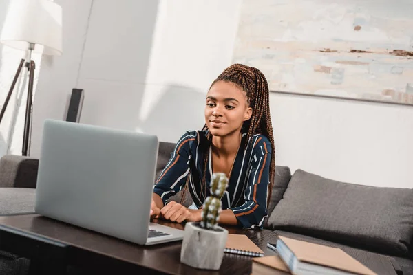 Woman using laptop on couch — Stock Photo, Image