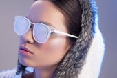 Trendfrau mit Sonnenbrille, die vom Frost bedeckt ist