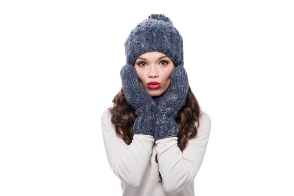 Surprised woman in mittens and hat