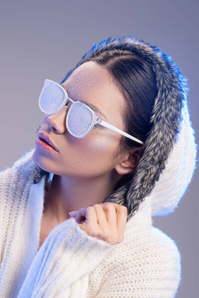 Fashionable woman in sunglasses covered in frost