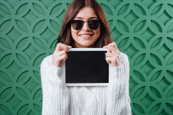 Frau im Pullover zeigt Tablet-Computer — Stockfoto