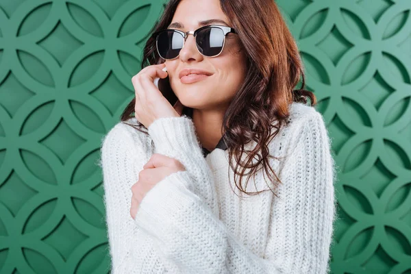 Kadın kazak ve smartphone ile konuşurken güneş gözlüğü — Stok fotoğraf