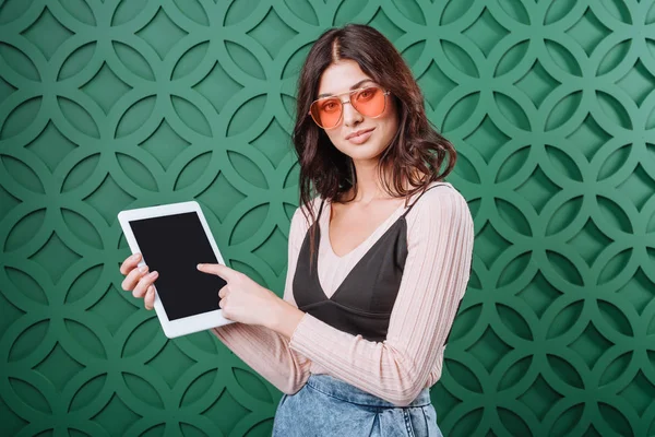 Woman in sunglasses showing at tablet computer — Stock Photo, Image