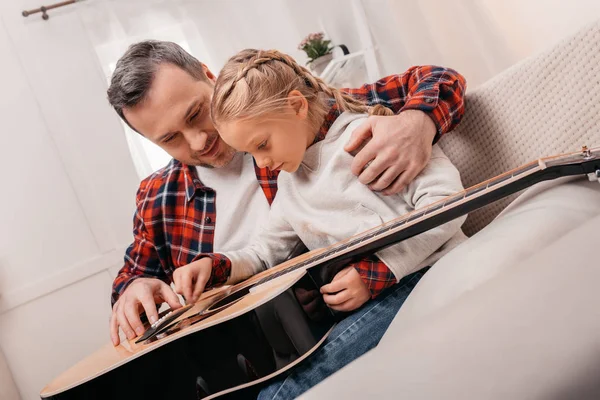 Отец и дочь играют на гитаре — стоковое фото