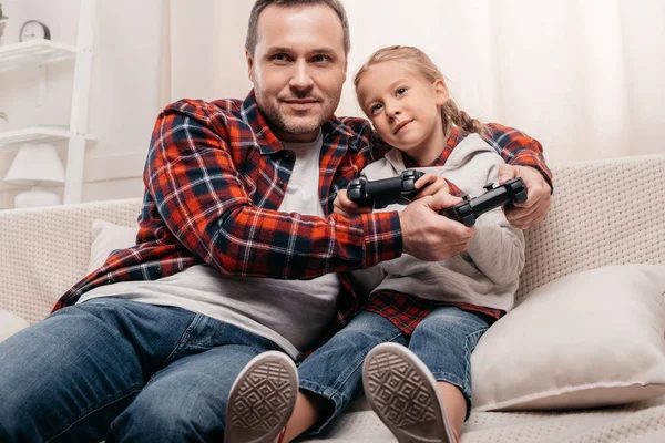 Far och dotter leker med joysticks — Stockfoto