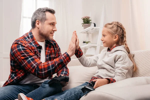 Vader en dochter spelen met joysticks — Stockfoto