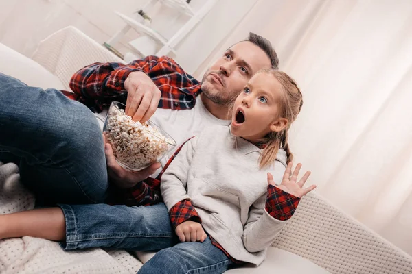 Father and daughter eating popcorn — Stock Photo, Image