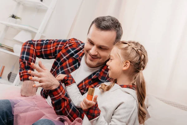 Father and daughter polishing nails — Free Stock Photo